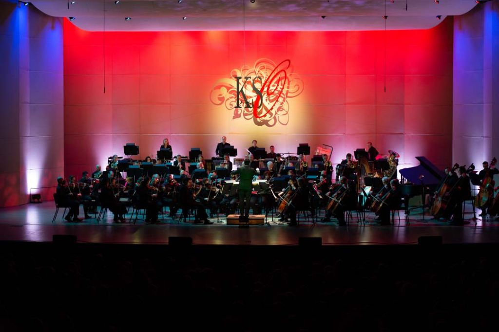 Concert Stage with full orchestra and contrasting red and blue lighting design